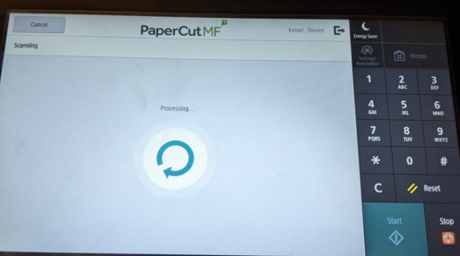 The printer touchscreen displaying a loading screen. The word "Processing" appears above a circular arrow icon.