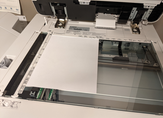 A piece of paper on the platen glass scanning bed. The content is facing downwards and the edges of the paper are flush against the top and left edges.
